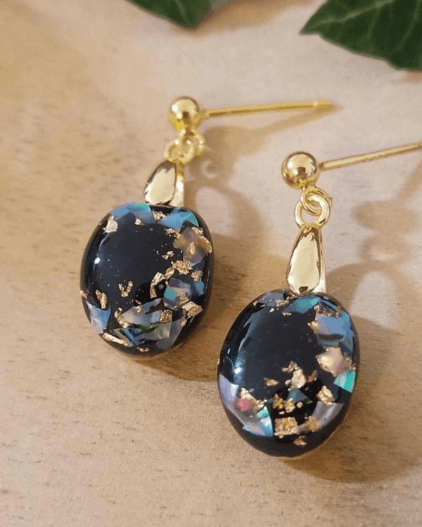 Boucles d'oreilles pendantes en nacre feuilles d'or sur fond noir. Argent plaqué or hypoallergénique