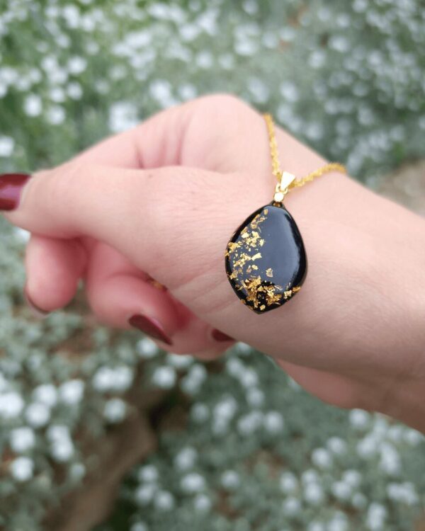 Collier sur fond noir avec insertion minitieuse de feuilles d'or. Pour un style précieux, élégant et raffiné.