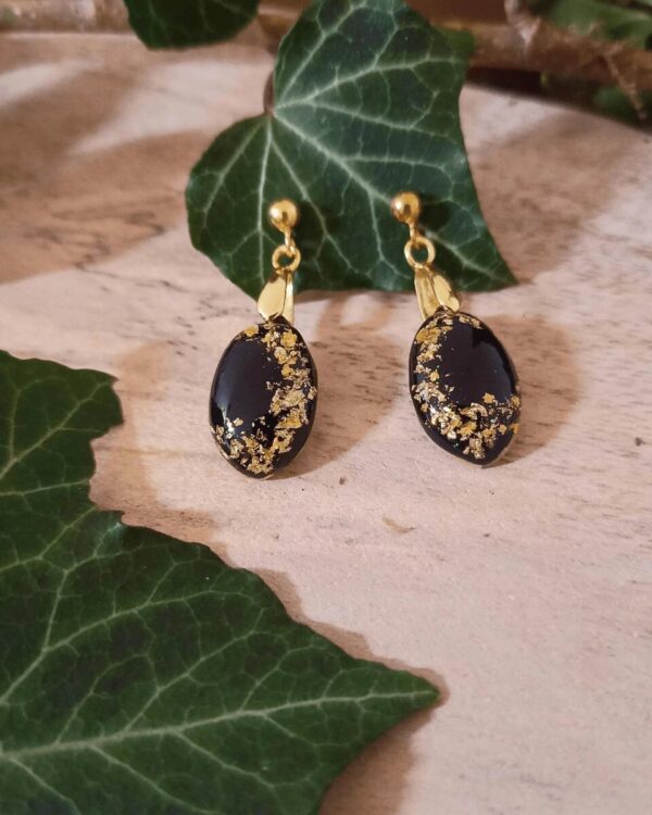 Boucles d'oreilles en forme de larme élancée avec insertion de feuilles d'or sur fond noir. Boucles en argent Sterling 925 plaqué or et support laiton.