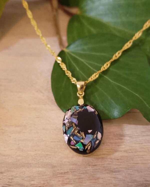 Collier avec nacre et laiton sur fond noir. Argent plaqué or. Bijoux pour femmes.