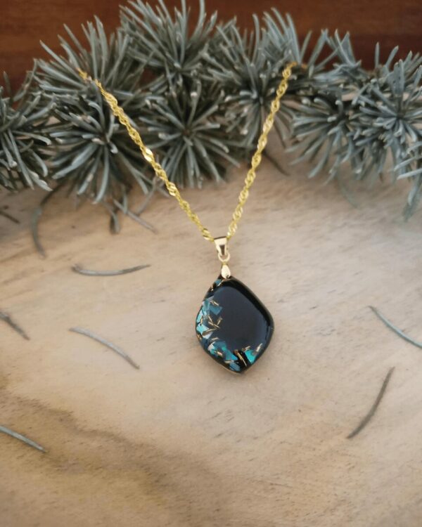 Collier en nacre bleue et éclat de laiton sur fond noir, comme un ciel nocturne où les étoiles se reflètent. Bijoux poétique et mystérieux